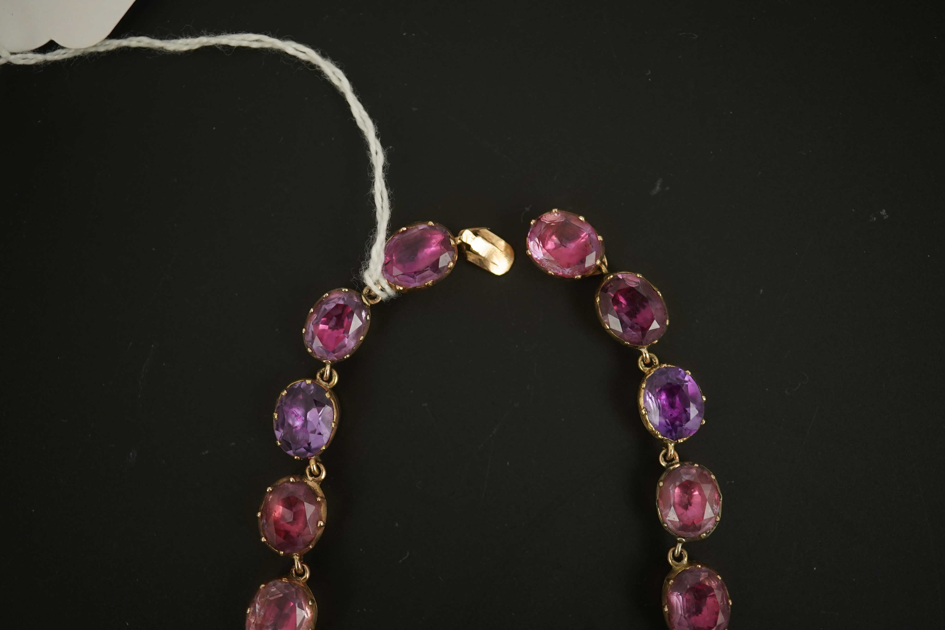 A 19th century gold and graduated oval cut foil backed amethyst or rock crystal set riviere necklace